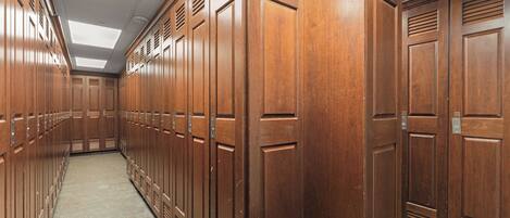 A corridor with wooden lockers, a tiled floor, and a skylight ceiling.