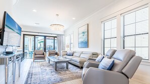Un salon spacieux avec un grand canapé, une table basse et un téléviseur.