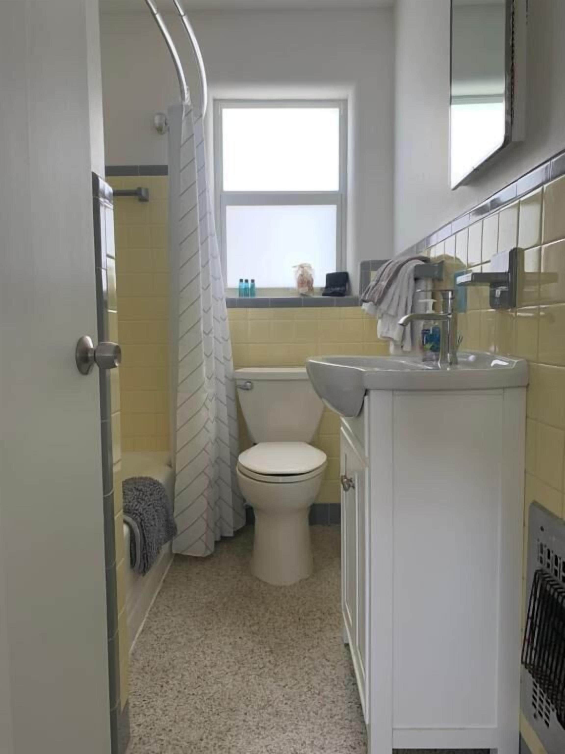 A bathroom with a toilet, sink, and shower area.