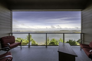Enjoy a tranquil view of the lake from this balcony, featuring a comfortable seating area with two chairs and a table.