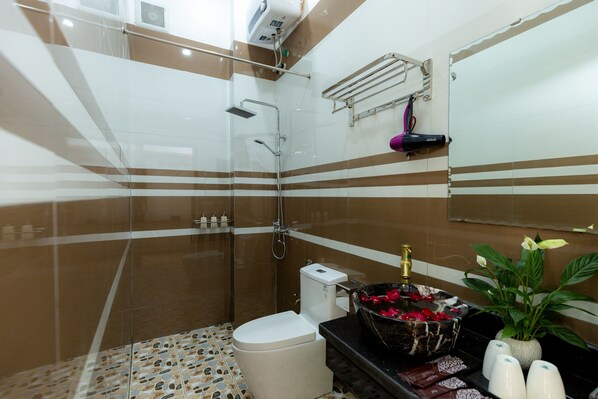 A modern bathroom with a glass shower enclosure, a marble sink, and a toilet. - Tam Coc Tuong Vy Homestay - Hostel (Nam Hoa Lu)