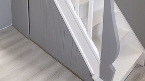 Eine Treppe mit weißen Geländern und einer grauen Wand.