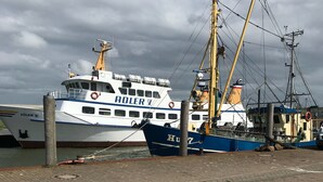 Eine Anlegestelle mit einem großen, weiß-blauen Boot namens 'HULFRY'.