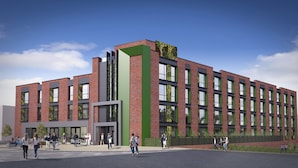 A modern building with a brick facade, large windows, and a green vertical element. - Lusso (Macclesfield)