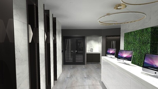 A modern reception area with a white reception desk, multiple monitors, and a green wall. - Lusso (Macclesfield)