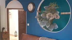 Een kamer met een blauwe wand, een houten deur, een klok en een ronde wandversiering.