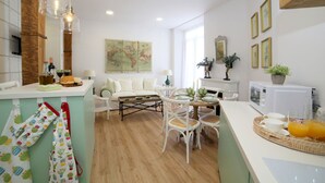 Cozinha e sala de estar modernas, com uma mesa de jantar posta para quatro pessoas, mobiliário branco e um mapa na parede.
