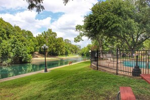Un parque con un río, una piscina y una banca.
