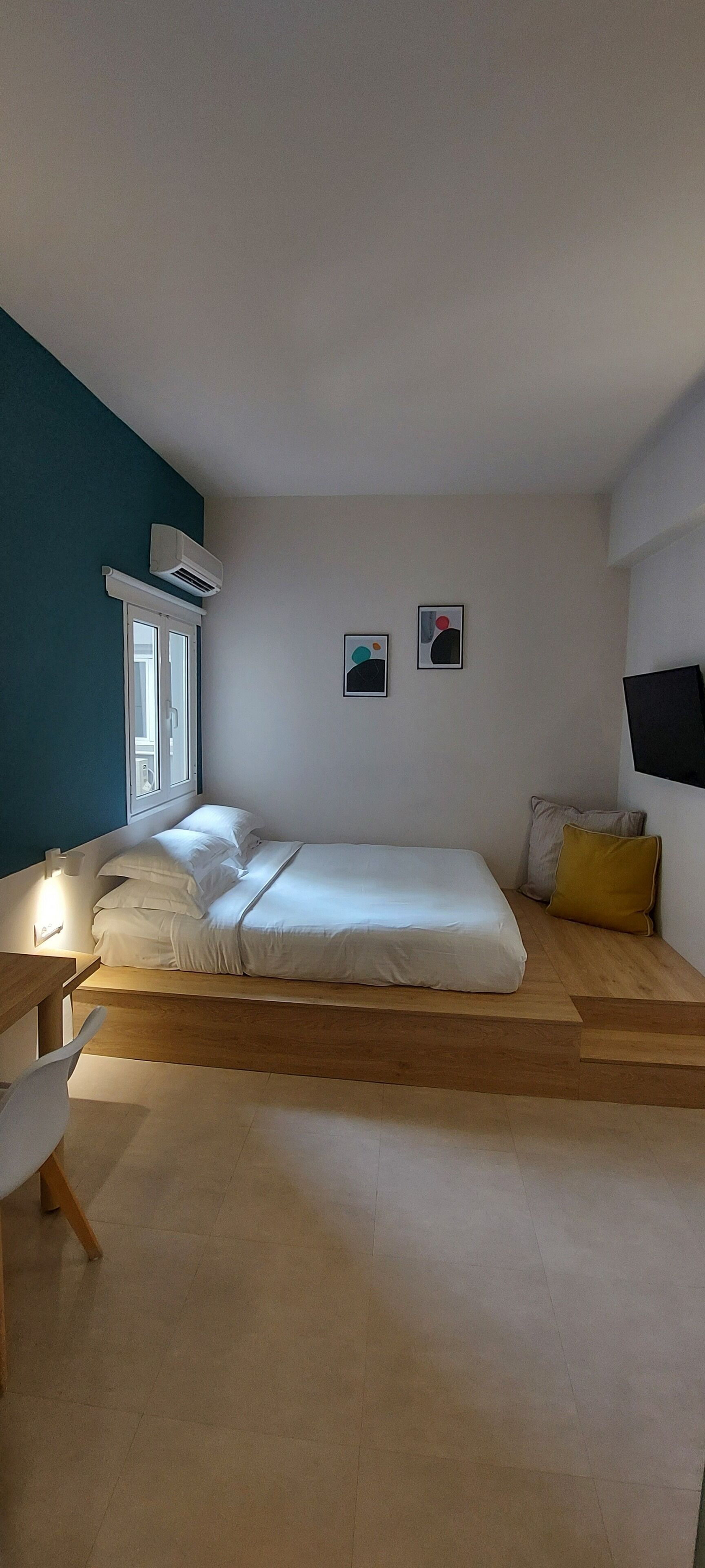 Une chambre à coucher avec un lit, une table de chevet et une fenêtre.