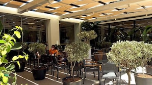 Un espacio al aire libre con plantas en macetas y mesas.