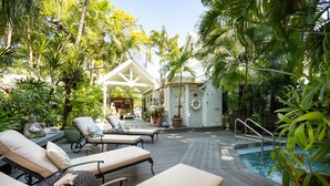 A poolside area with lounge chairs, a covered seating area, and a small pool. - The Mermaid & Alligator (Key West)