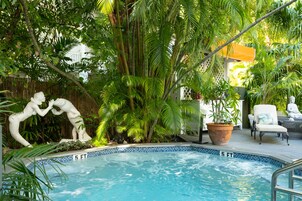 Una piscina al aire libre, sillones reclinables de piscina