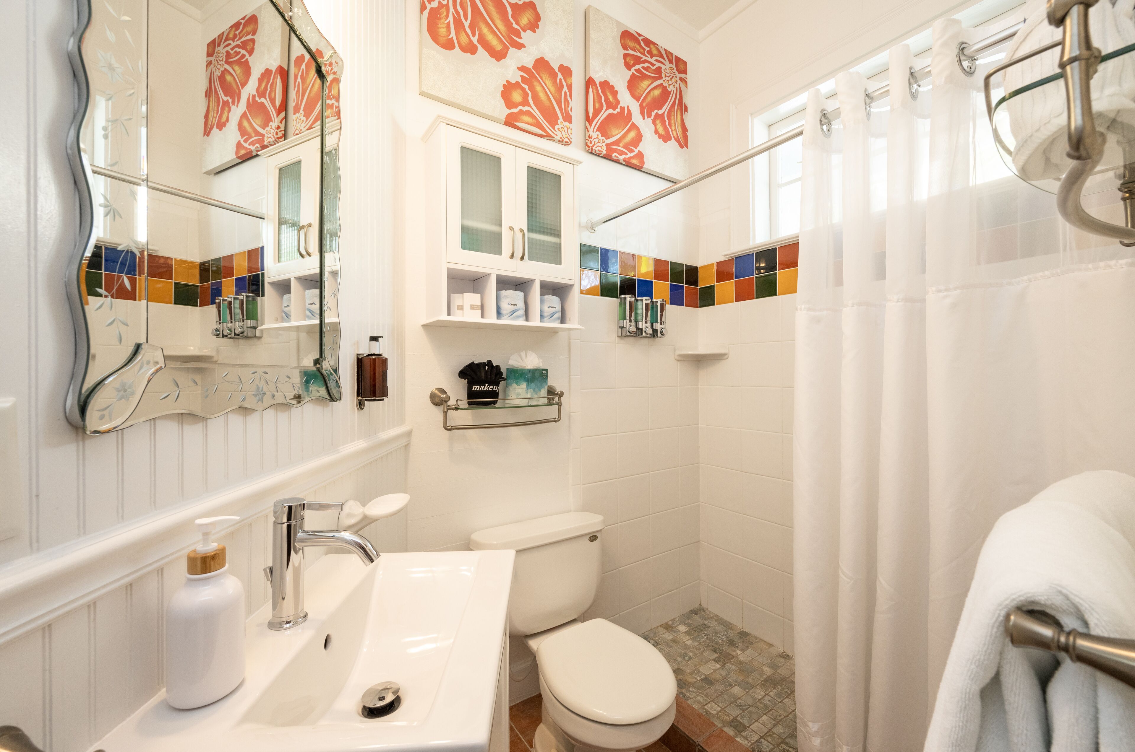 Une salle de bain avec un lavabo blanc, des toilettes et un rideau de douche.