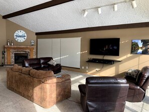 Cozy living room with a fireplace, flat-screen TV, and comfortable seating.