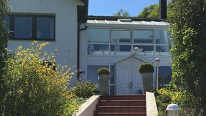 A set of outdoor stairs leading to a white double-decker house with a number '18' on the wall. - Apartment mit Burgblick im Grünen, Familie Held (Burgthann)