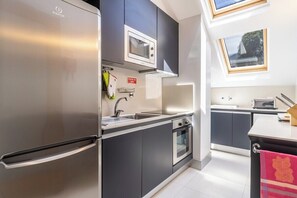A modern kitchen with a stainless steel refrigerator, a microwave, and an oven. - Santa Luzia Funchal View | 2br pool, ac & parking (Funchal)