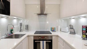Een moderne keuken met roestvrijstalen apparatuur, een inbouwoven en een vaatwasser.
