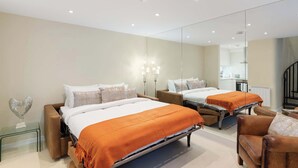 Een moderne hotelkamer met een groot bed, een bank, een tafeltje en een spiegel.