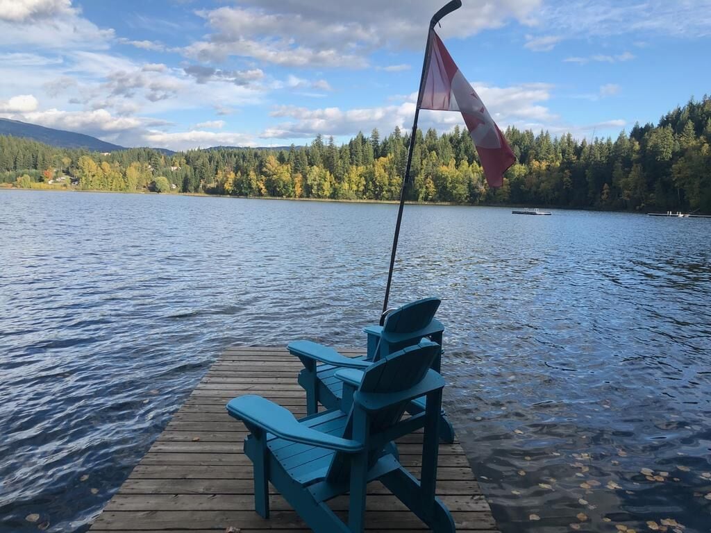 A wooden dock with chairs and a flag.