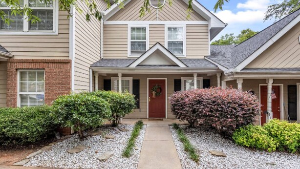 A two-story house with a front porch, a brick foundation, and a gravel driveway. - Chefs Kitchen, King Beds, Smart TVs. Close to downtown! Dead End Street (Greenville)