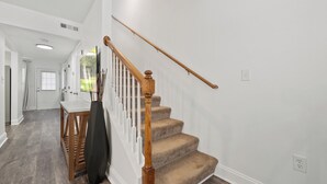 A staircase with wooden balusters and carpeted steps leading to a landing. - Chefs Kitchen, King Beds, Smart TVs. Close to downtown! Dead End Street (Greenville)