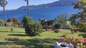Une vue sur la côte, avec une maison, des palmiers et une vaste étendue d’eau.