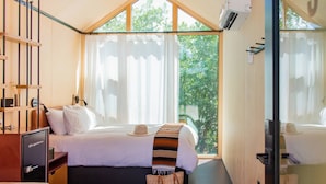 Un dormitorio moderno con un ventanal grande, una cama, una mesita de noche y un armario.
