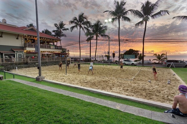 Un terrain de beach-volley avec un restaurant en arrière-plan.