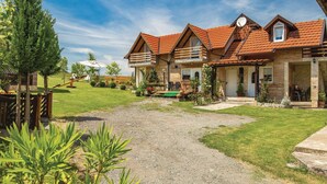 A row of log cabins with a gravel driveway leading to a wooden deck. - Nice Home in Licko Lesce With 2 Bedrooms and Wifi (Otocac)