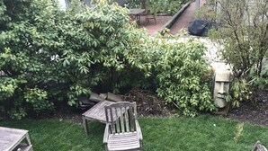 Un giardino con un tavolo di legno e quattro sedie disposte attorno.