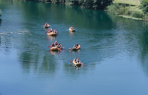 A group of people in inflatable rafts on a calm river.