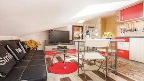 A compact living space with a sofa, a TV, a dining area, and a kitchen. - Amazing Home in Opatija With Wifi and 0 Bedrooms (Opatija)