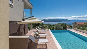 A poolside area with a view of the sea and mountains, sun loungers, and a covered seating area. - Beautiful Home in Plomin With Jacuzzi, Wifi and 1 Bedrooms (Krsan)