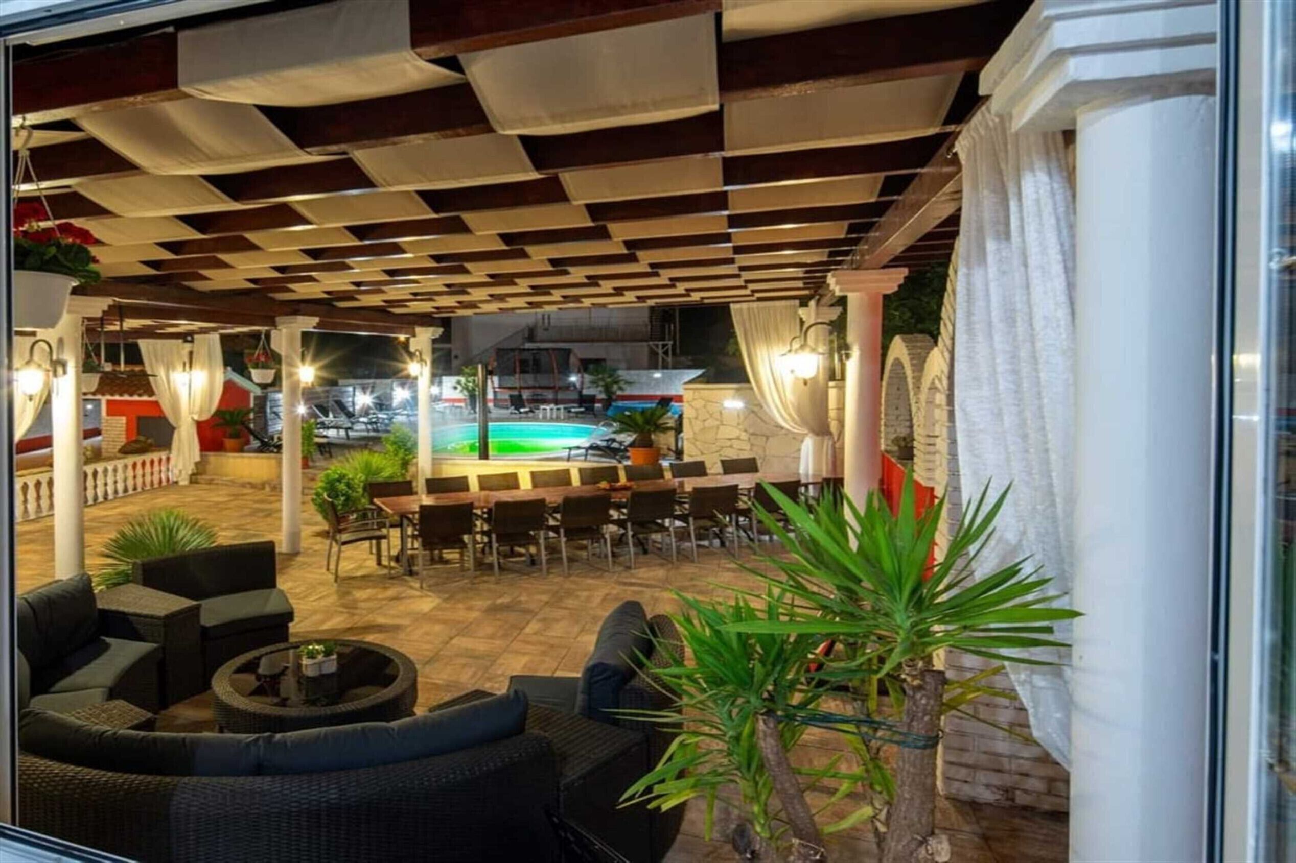 Un espace extérieur aménagé avec une terrasse, une piscine, des coins salon et une vue sur la piscine.