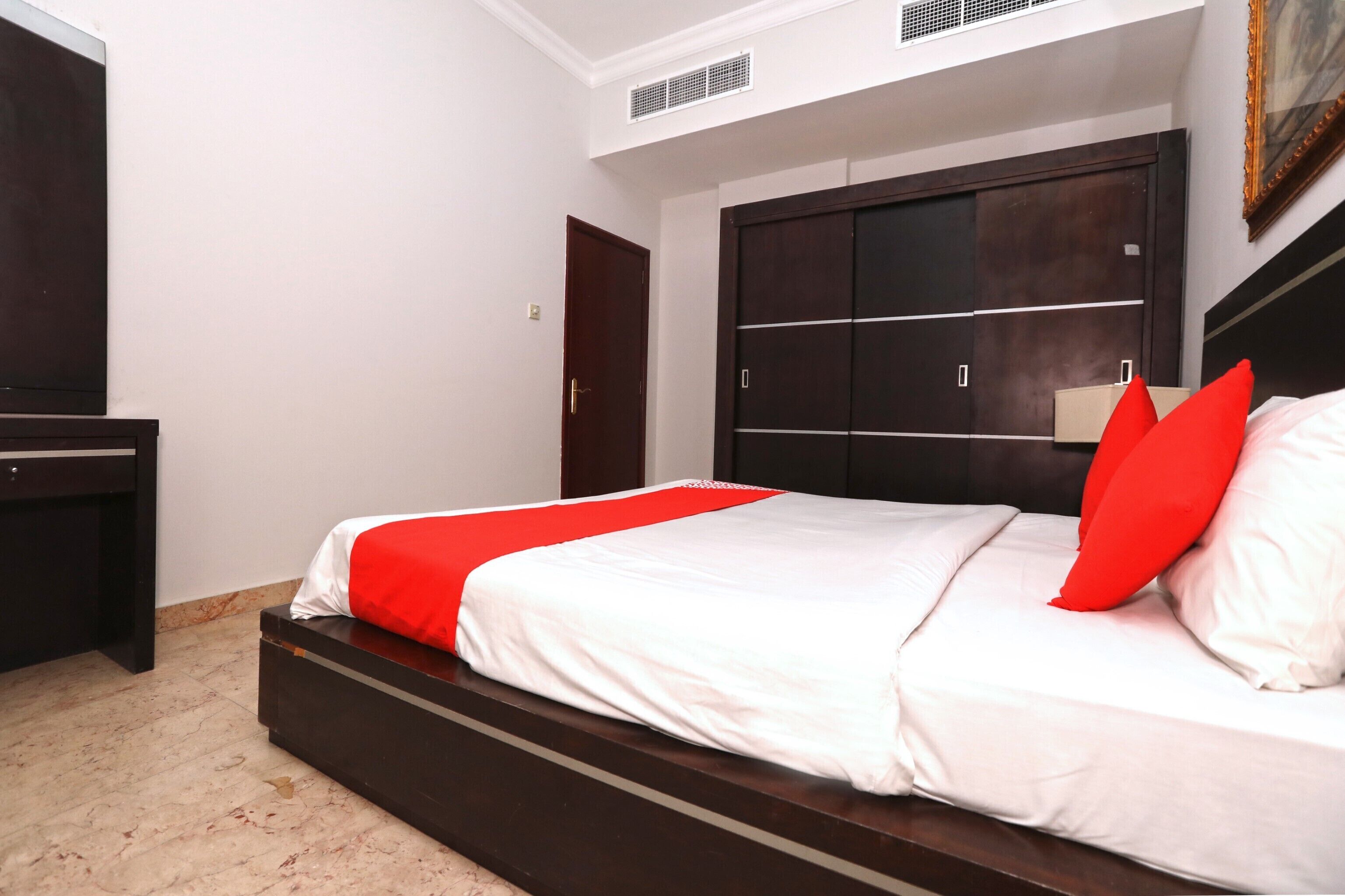 A bedroom with a bed, a wardrobe, and a desk.