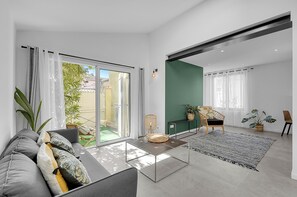 A modern living room with a sofa, coffee table, and a view of the outside.
