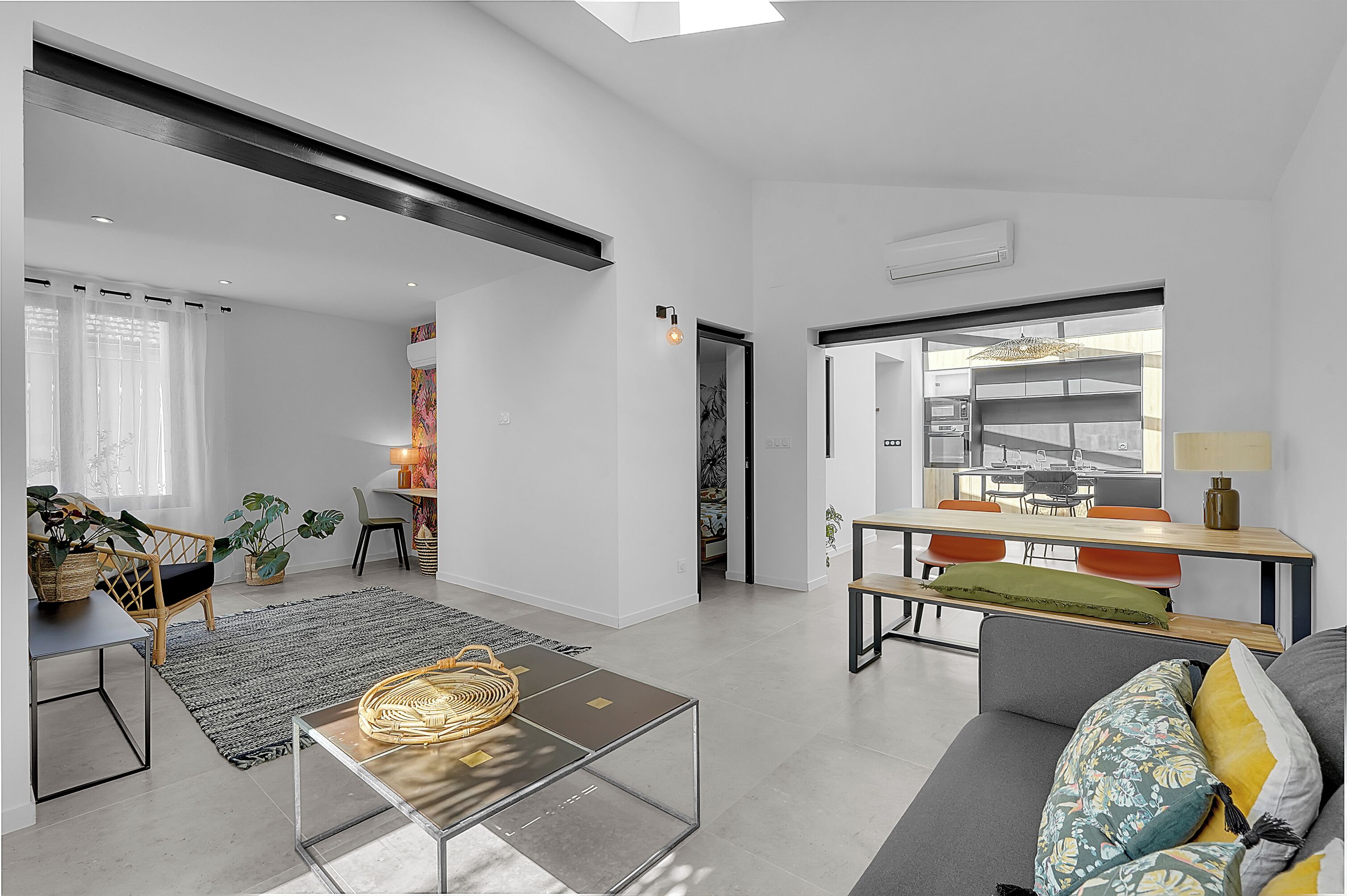 A modern living space with a sofa, coffee table, and dining area.