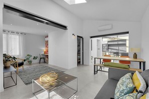 A modern living space with a sofa, coffee table, and dining area.