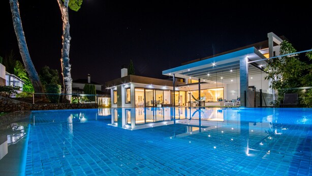 A modern pool area with a glass enclosure and a well-lit interior.