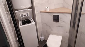Ein modernes Badezimmer mit Toilette, Wasserspender und Duschbereich.
