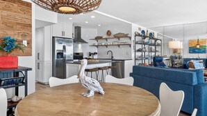 A modern kitchen with a central island, white cabinetry, and stainless steel appliances. - Sea Gull #907: Beachfront 2 Bedroom 2 Bathroom With Spectacular Views and 24 Hour Management (Port Aransas)
