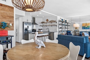 A modern kitchen with a central island, white cabinetry, and stainless steel appliances.