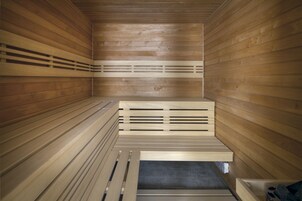Una sauna con panche e sedute in legno a listarelle.