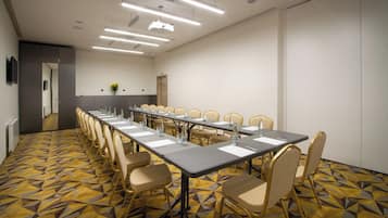 A conference room with a long table, chairs, and a patterned carpet.