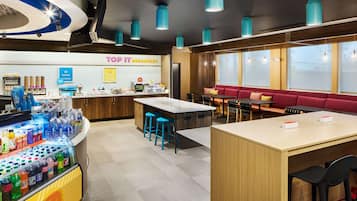 Un espace moderne dédié au petit-déjeuner, comprenant un comptoir, un bar et des sièges.