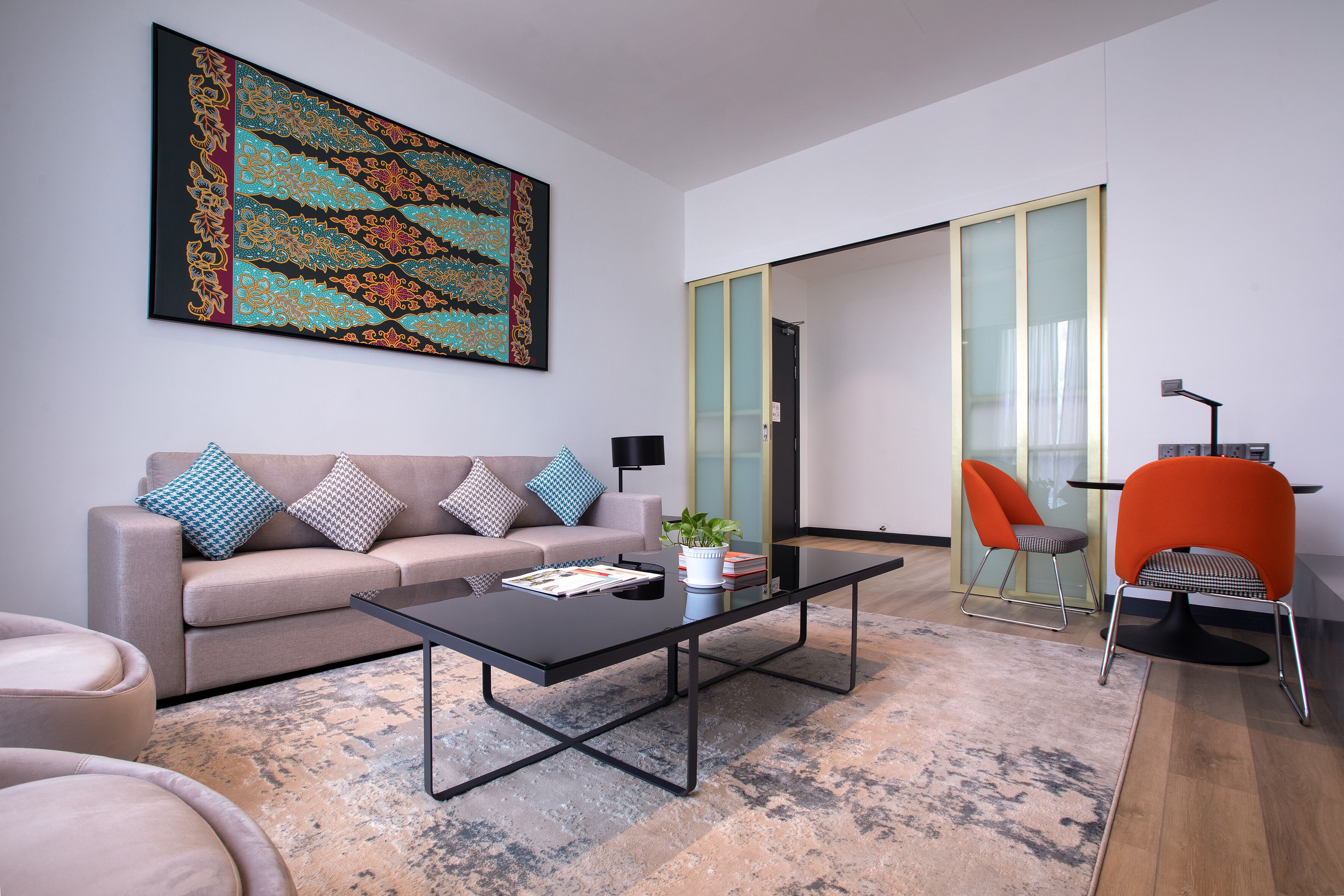 A modern living room with a sofa, coffee table, and chairs.
