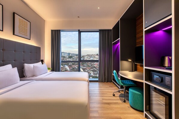Une chambre d’hôtel avec deux lits, un bureau, une chaise et une vue sur la ville.