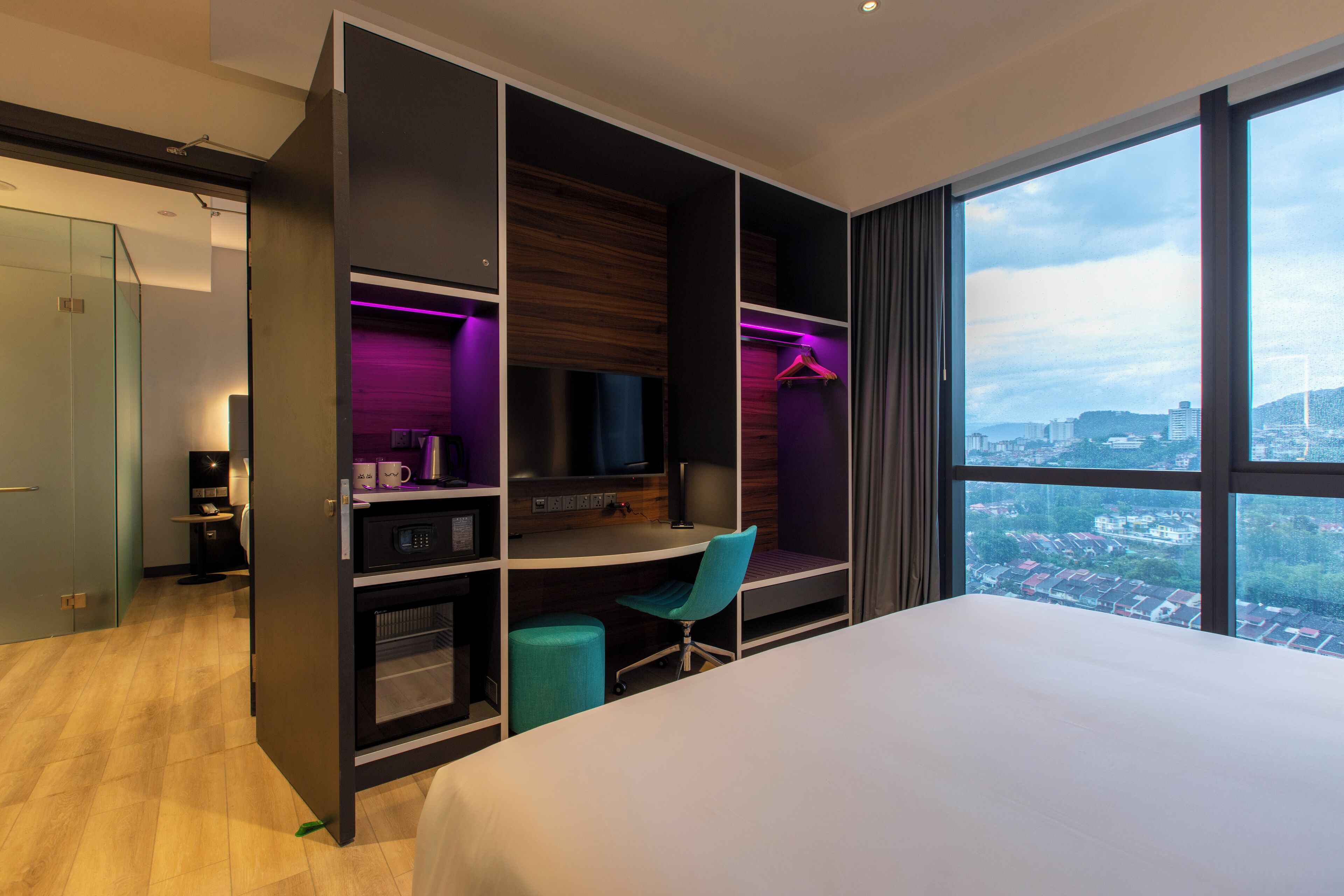 Une chambre d’hôtel moderne, dotée d’un grand lit, d’un bureau et d’une armoire.