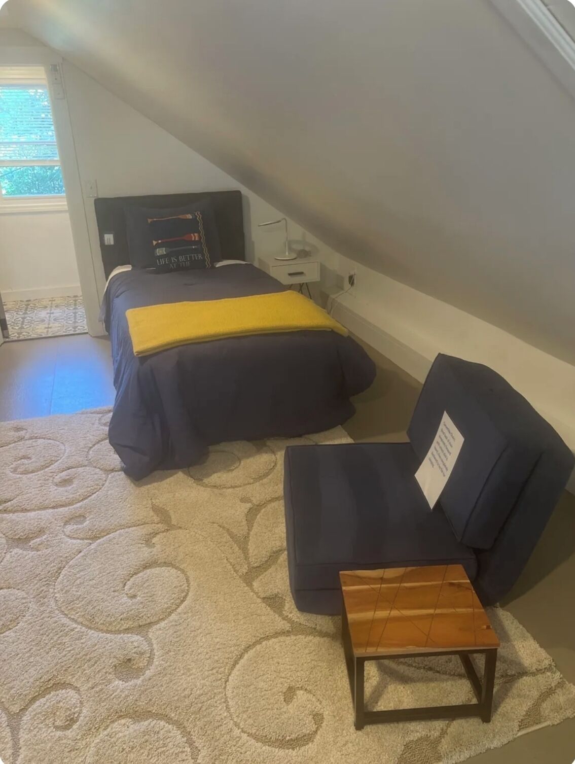 A small, cozy room with a bed, a sofa, and a small table.