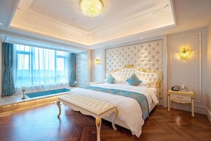 Um quarto luxuoso com uma cama grande, um banco e uma mesa de cabeceira.